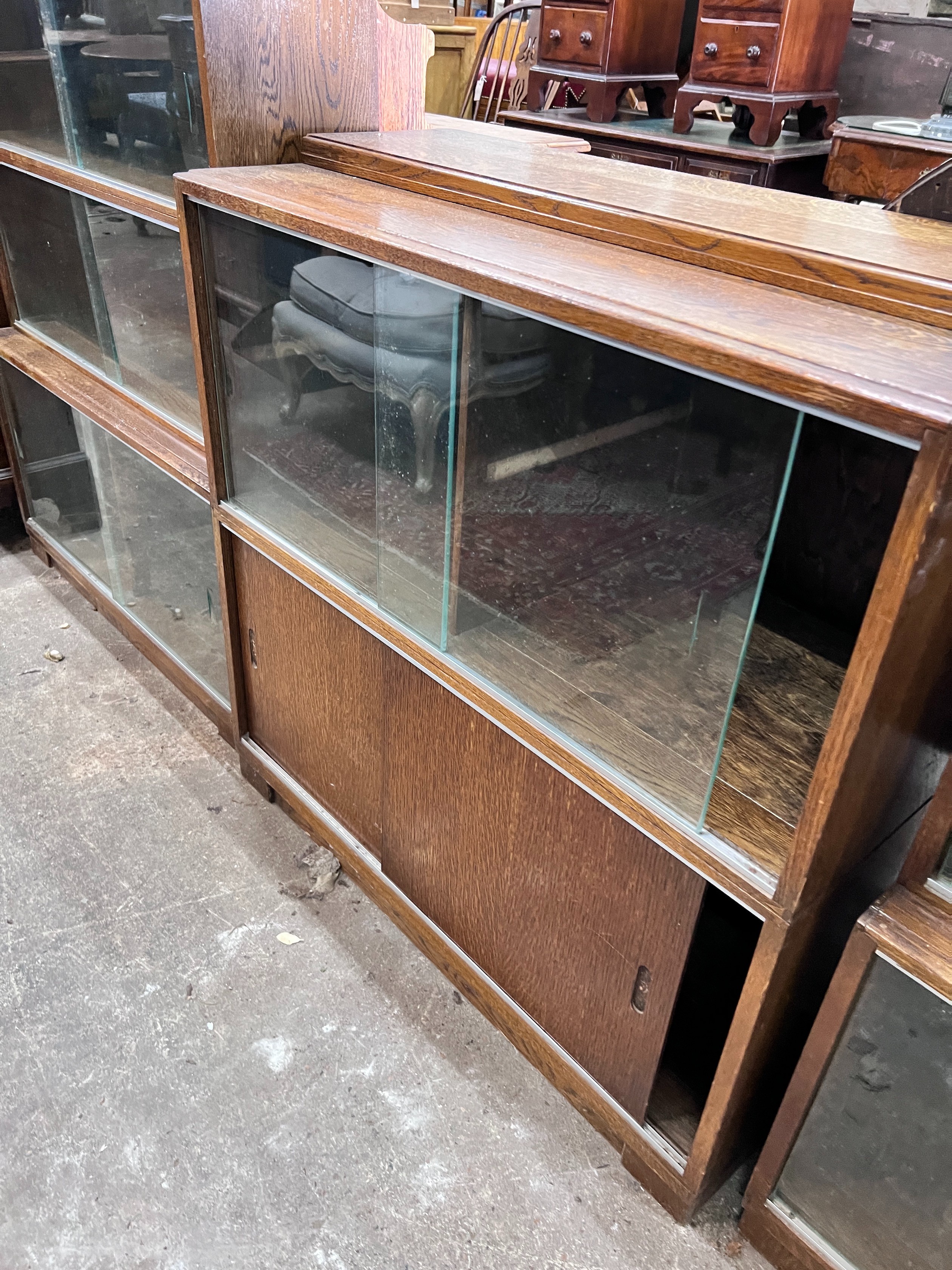 Five 1960's oak Minty bookcases comprising two four section, one three section, and a near pair of two section bookcases, widest 89cm, depth 30cm, height 135cm *Please note the sale commences at 9am.